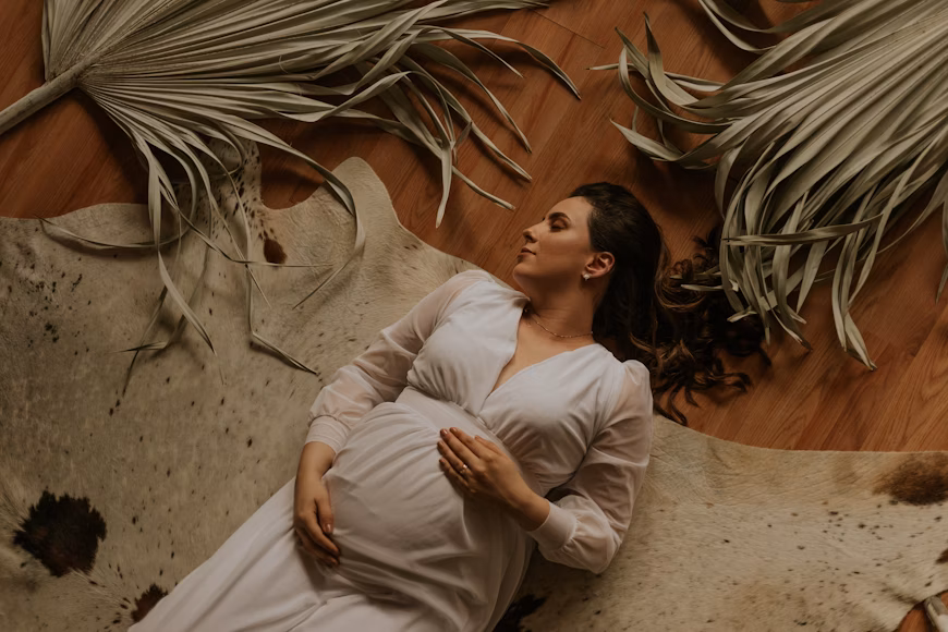 tired pregnant woman dressed in white